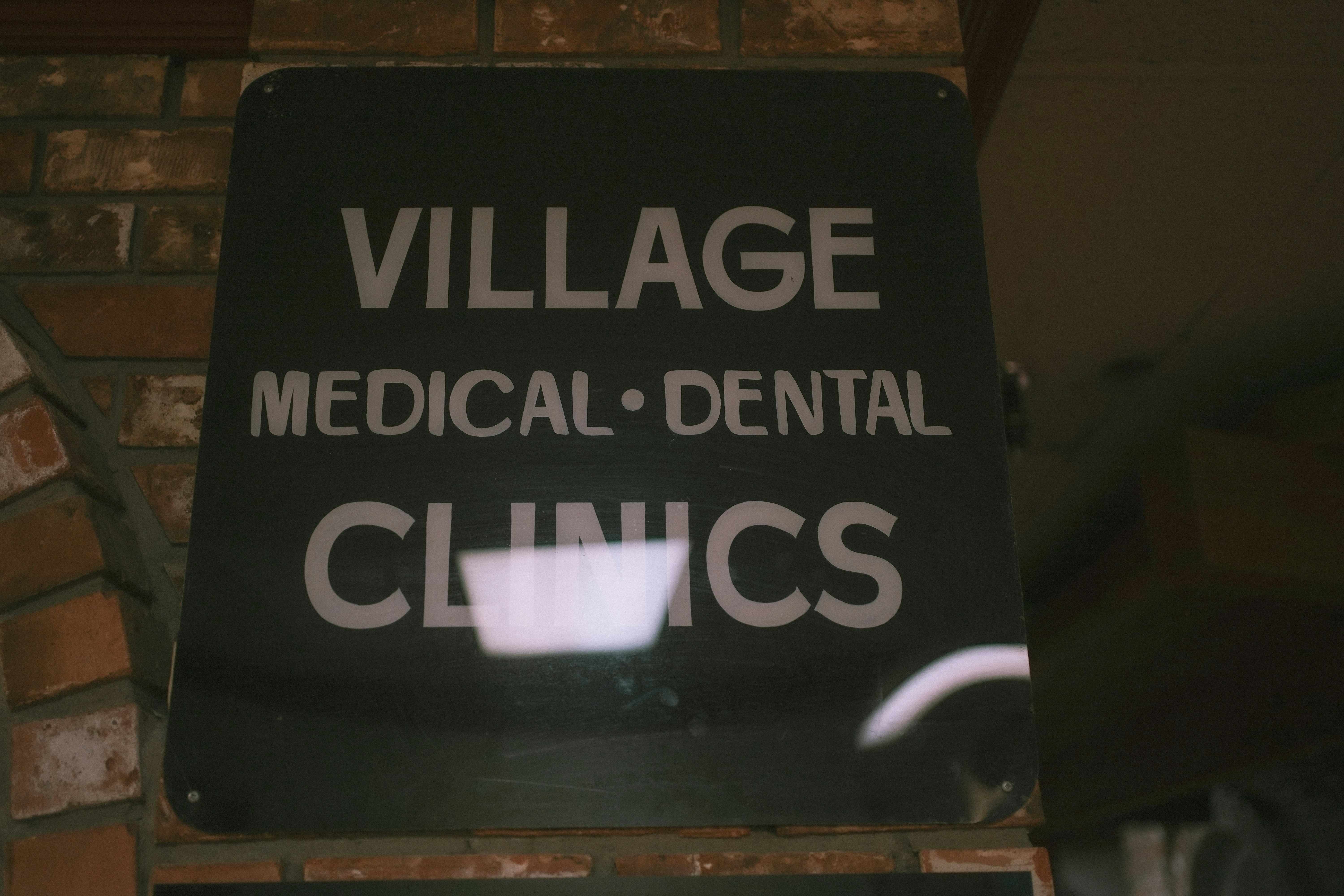 A black and white sign that says village medical dental clinic
